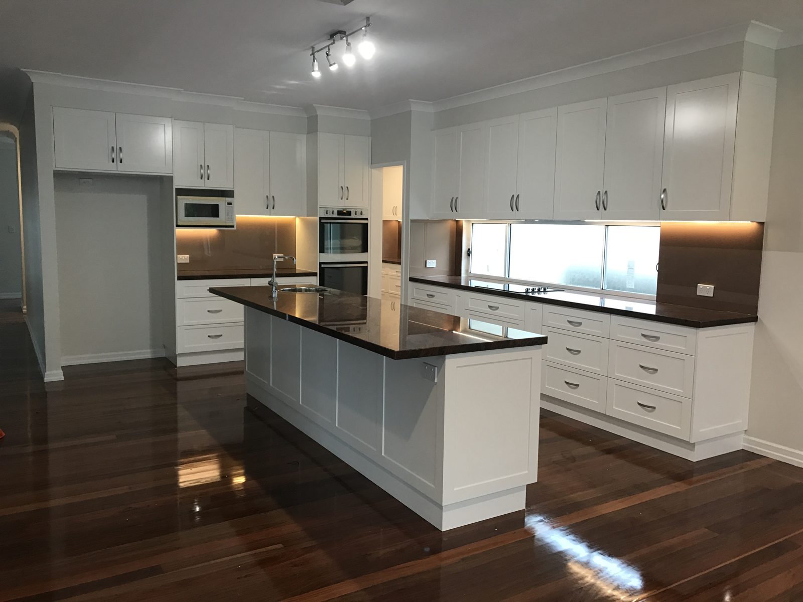 White shaker kitchen with dark stone benches